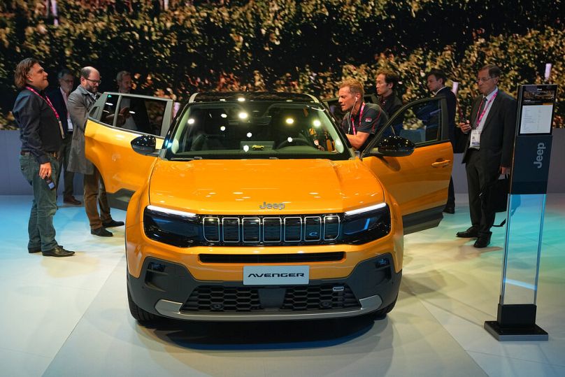 Les gens se rassemblent autour du SUV Jeep Avenger électrique au Salon de l'automobile de Paris le lundi 17 octobre 2022 à Paris.