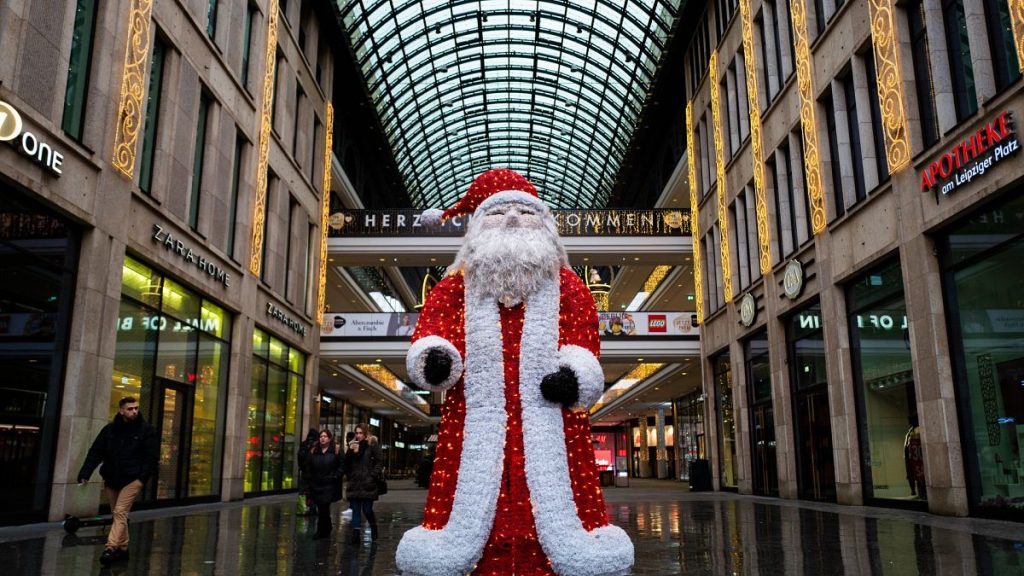 A likeness of Santa Claus stands outside a shopping mall in Berlin on December 24, 2021. John MACDOUGALL / AFP