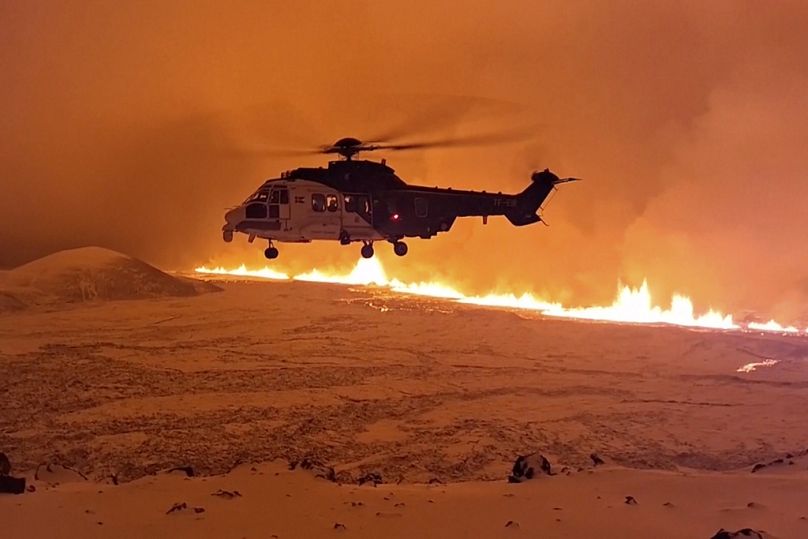 Cette image réalisée à partir d'une vidéo fournie par les garde-côtes islandais montre son hélicoptère volant près du magma courant sur une colline près de Grindavik, dans la péninsule islandaise de Reykjanes.