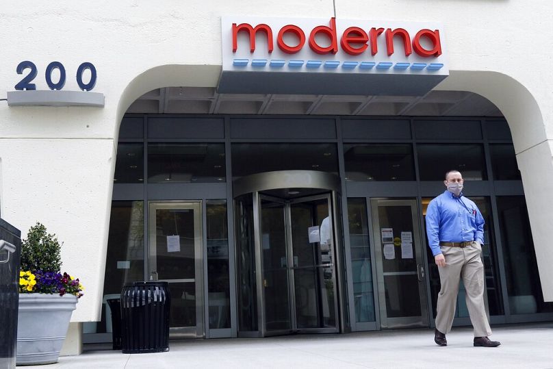 Un homme se tient devant l’entrée d’un bâtiment Moderna à Cambridge, mai 2020