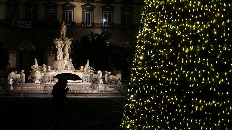 Les lumières d'un sapin de Noël ont pour toile de fond la fontaine de Neptune à Naples, en Italie, en décembre 2021.