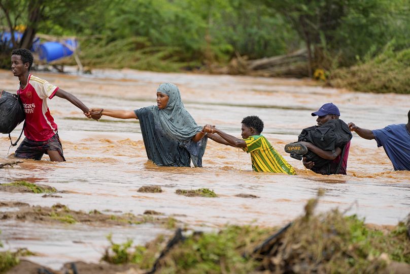 Des habitants traversent une route endommagée par les pluies d'El Niño à Tula, dans le comté de Tana River au Kenya, en novembre.