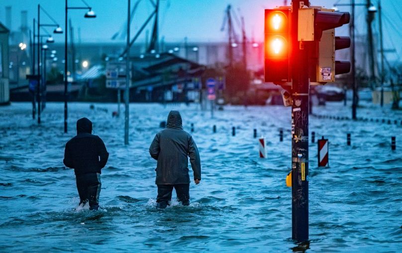 Des gens traversent une rue inondée à Flensburg, en Allemagne, en octobre, alors que la tempête Babet fait des ravages.