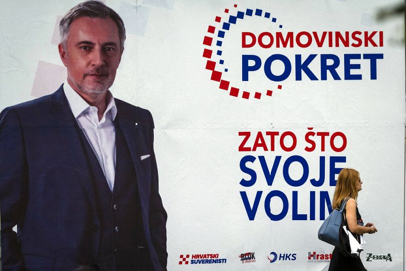 Une femme passe devant une affiche électorale de Miroslav Skoro, chanteur folk et leader du mouvement de droite pour la patrie, à Zagreb, en juillet 2020.