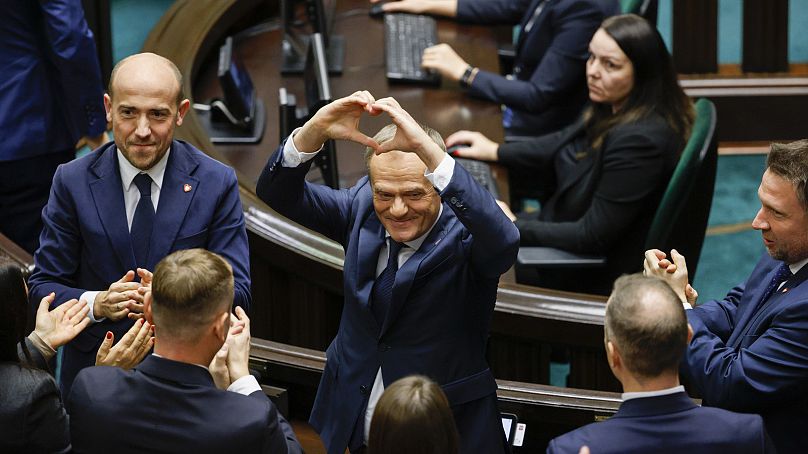 Donald Tusk montre un cœur avec ses mains après avoir été élu Premier ministre polonais, le 11 décembre