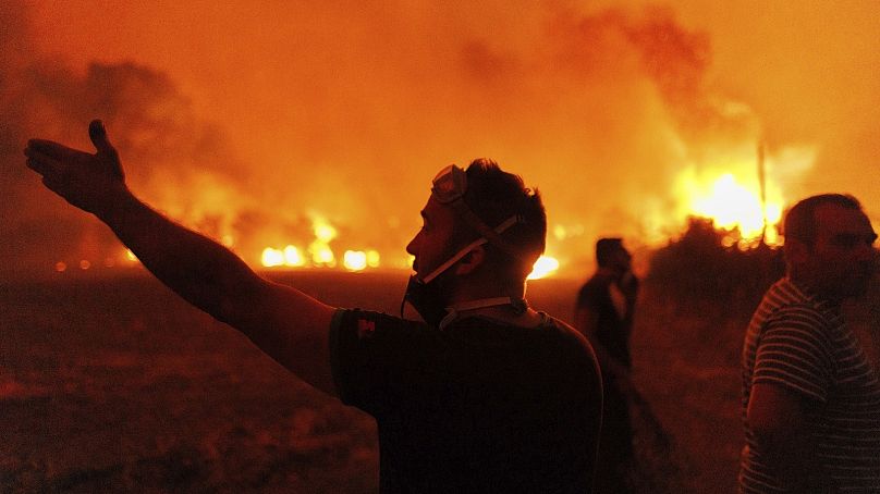 Les gens réagissent alors qu'ils tentent d'éteindre un incendie de forêt dans le village d'Avantas, près de la ville d'Alexandroupolis, dans la région nord-est d'Evros, en Grèce, le 21 août.