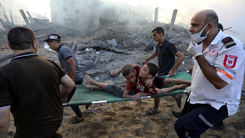 Les Palestiniens évacuent deux garçons blessés suite aux frappes aériennes israéliennes sur la ville de Gaza, le 25 octobre