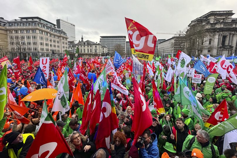 Des manifestants brandissent des drapeaux et se rassemblent lors d'une manifestation contre les mesures d'austérité à Bruxelles, le 12 décembre 2023.