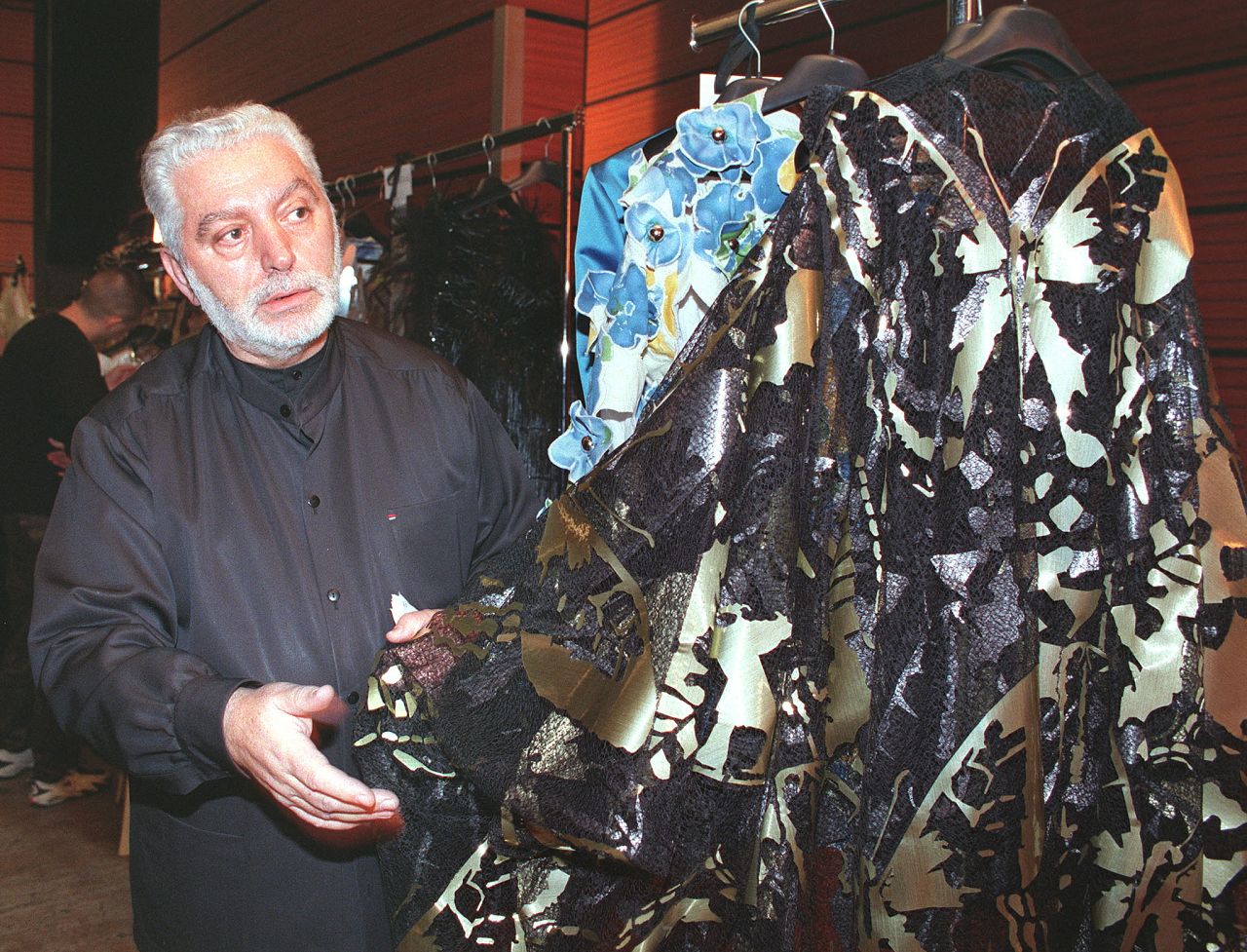 Le couturier Paco Rabanne vérifie une robe avant la présentation de sa collection haute-couture Printemps/été 1999, le 20 janvier 1999 à Paris.