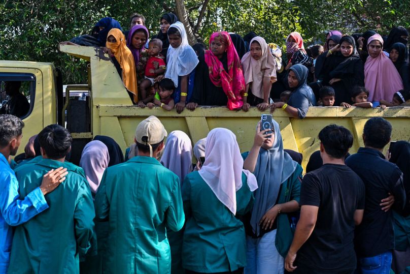 Les réfugiés rohingyas se rassemblent dans un véhicule pour être transférés vers un bâtiment gouvernemental voisin après avoir manifesté contre des étudiants universitaires qui les ont forcés à quitter leur domicile temporaire.