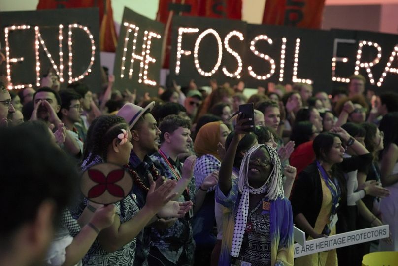 La militante Ina-Maria Shikongo prend des photos lors d'une manifestation pour mettre fin aux combustibles fossiles à la COP28.