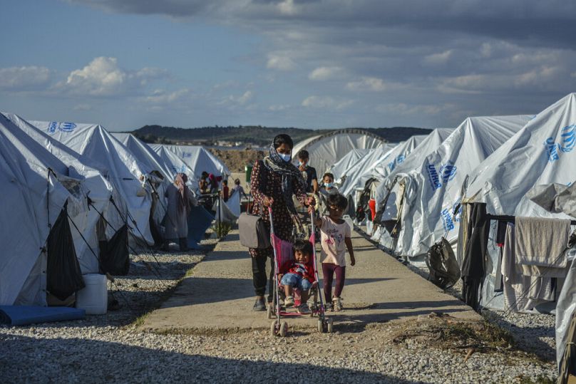 Des migrants marchent après une tempête de pluie dans le camp de réfugiés de Kara Tepe, sur l'île de Lesbos, au nord-est de la mer Égée, en octobre 2020.