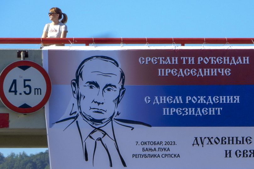 Une femme passe devant un panneau publicitaire avec une image du président russe Vladimir Poutine et lit : "Joyeux anniversaire au Président'', dans la ville bosniaque de Banja Luka, octobre 2023