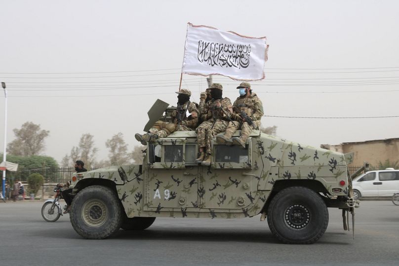 Des combattants talibans patrouillent sur la route lors d'une célébration marquant le deuxième anniversaire du retrait des troupes dirigées par les États-Unis à Kandahar, août 2023.