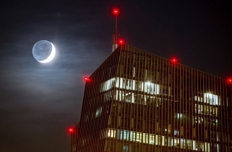 La lune croissante passe derrière la Banque centrale européenne à Francfort, décembre 2023