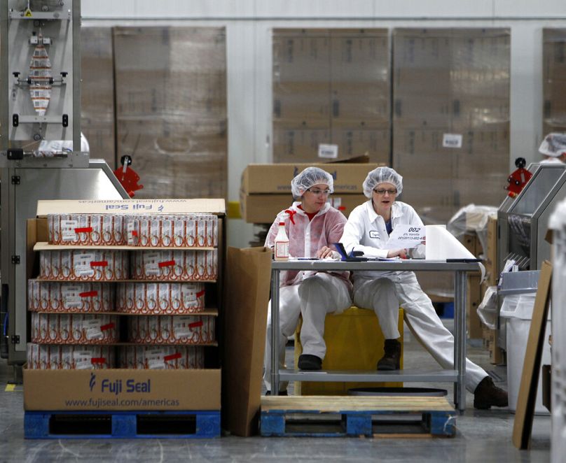 Deux employés travaillent dans l'usine de manchonnage où les étiquettes sont apposées sur les contenants de Chobani Greek Yogurt, dans le sud d'Edmeston, en janvier 2012.