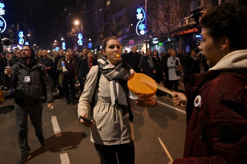 Un manifestant siffle alors que des partisans de l'opposition participent à une marche lors d'une manifestation à Belgrade, le 25 décembre 2023, une semaine après les élections générales.