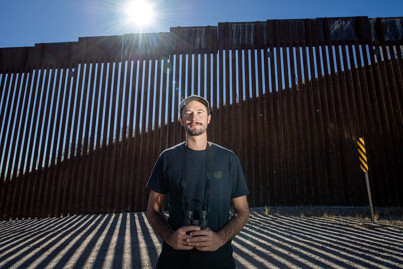 Laiken Jordahl, défenseur de la conservation du Sud-Ouest, pose à côté du mur frontalier américano-mexicain à Sasabe, en Arizona.