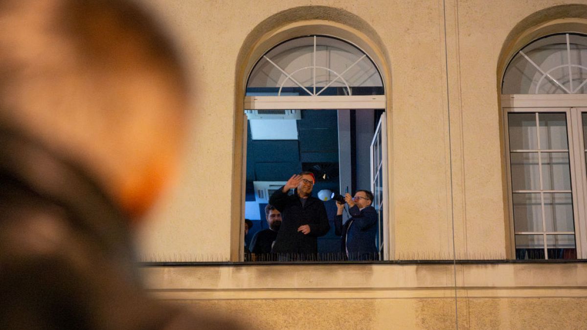 Journalist and protest leader Michal Adamczyk waves to a crowd of protesters at the TVP Info office in Warsaw after staff at public media institutions were dismissed