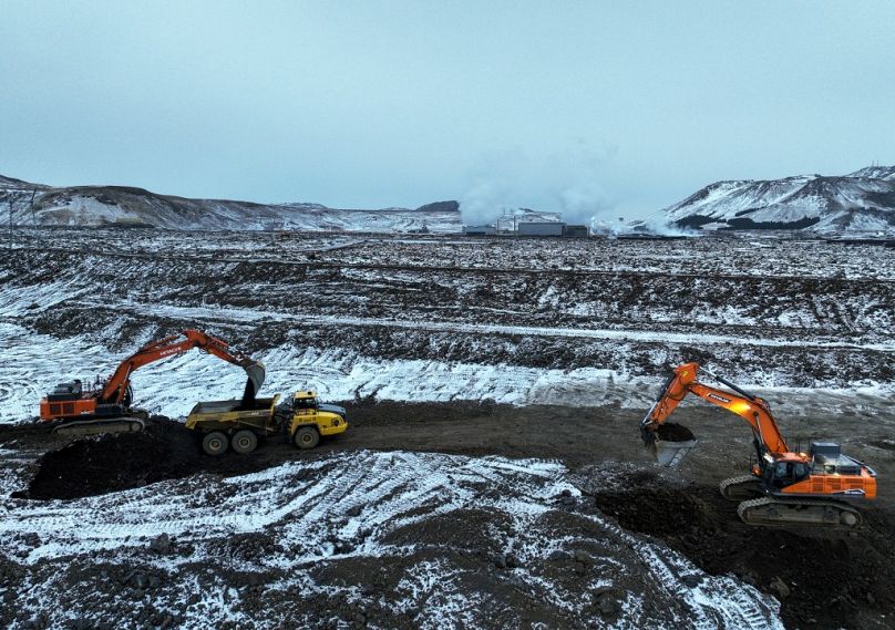 Les travaux se poursuivent sur un mur de défense nouvellement construit autour du bain thermal d'eau de mer emblématique, du Blue Lagoon et de la centrale électrique de Svartsengi derrière, près de Grindavik, dans l'ouest de l'Islande.