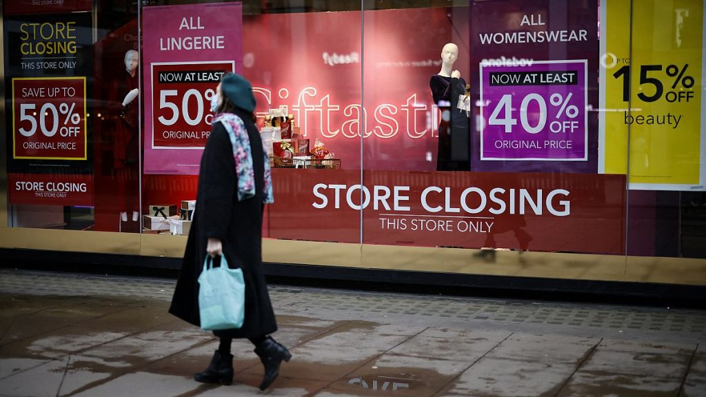 Pedestrians walk past the window display of a Debenhams shop on Oxford Street in central London on December 22, 2020.