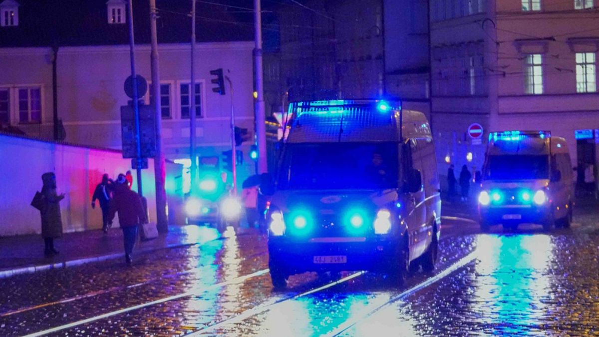 Police vehicles drive towards the building housing the Philosophical Faculty of Charles University in downtown Prague, 21 December 2023