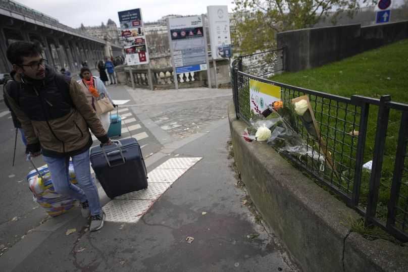 Un homme passe devant des fleurs placées sur les lieux où un homme a pris pour cible des passants samedi soir, tuant un touriste allemand.