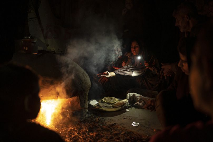 Des Palestiniens déplacés par le bombardement israélien sur la bande de Gaza cuisinent dimanche dans un camp de tentes de fortune dans la région de Muwasi.