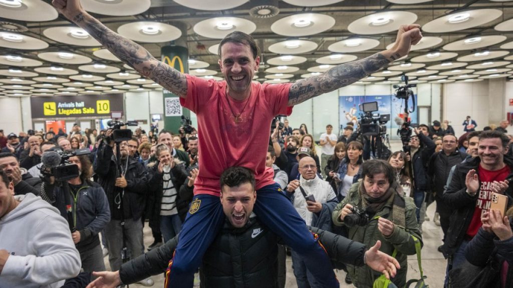 Spanish Santiago Sanchez Cogedor, top, is welcomed by friends and family members at the Barajas airport, outskirts of Madrid, Spain.