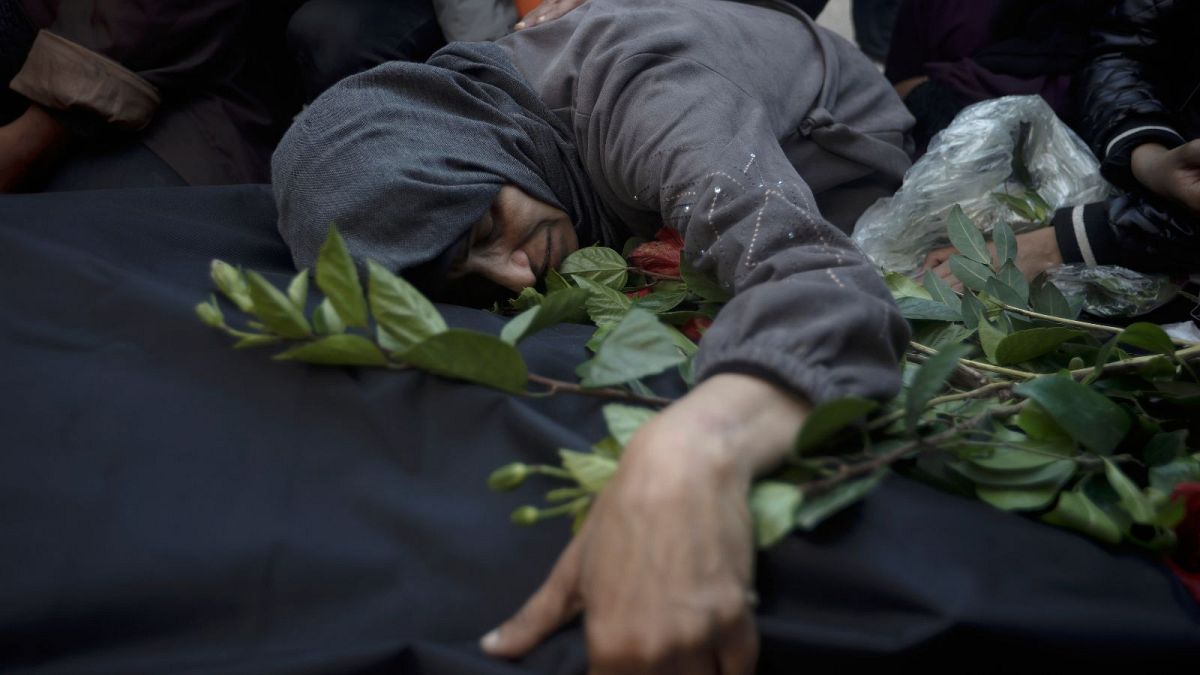 Palestinians mourn relatives killed in the Israeli bombardment of the Gaza Strip outside a morgue in Khan Younis on Sunday, Dec. 24, 2023.