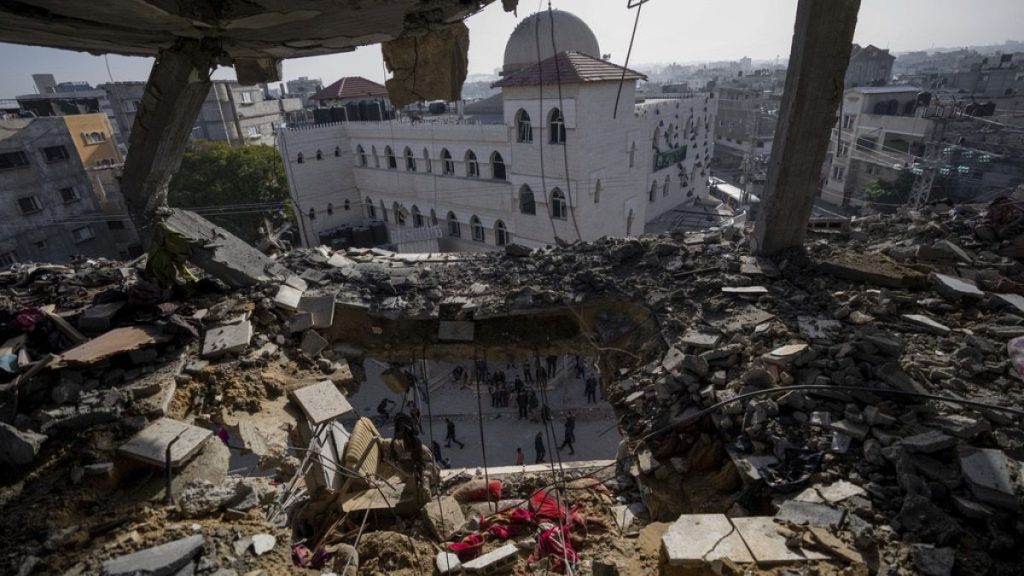 Palestinians look at a damaged residential building after an Israeli strike in Rafah, southern Gaza Strip