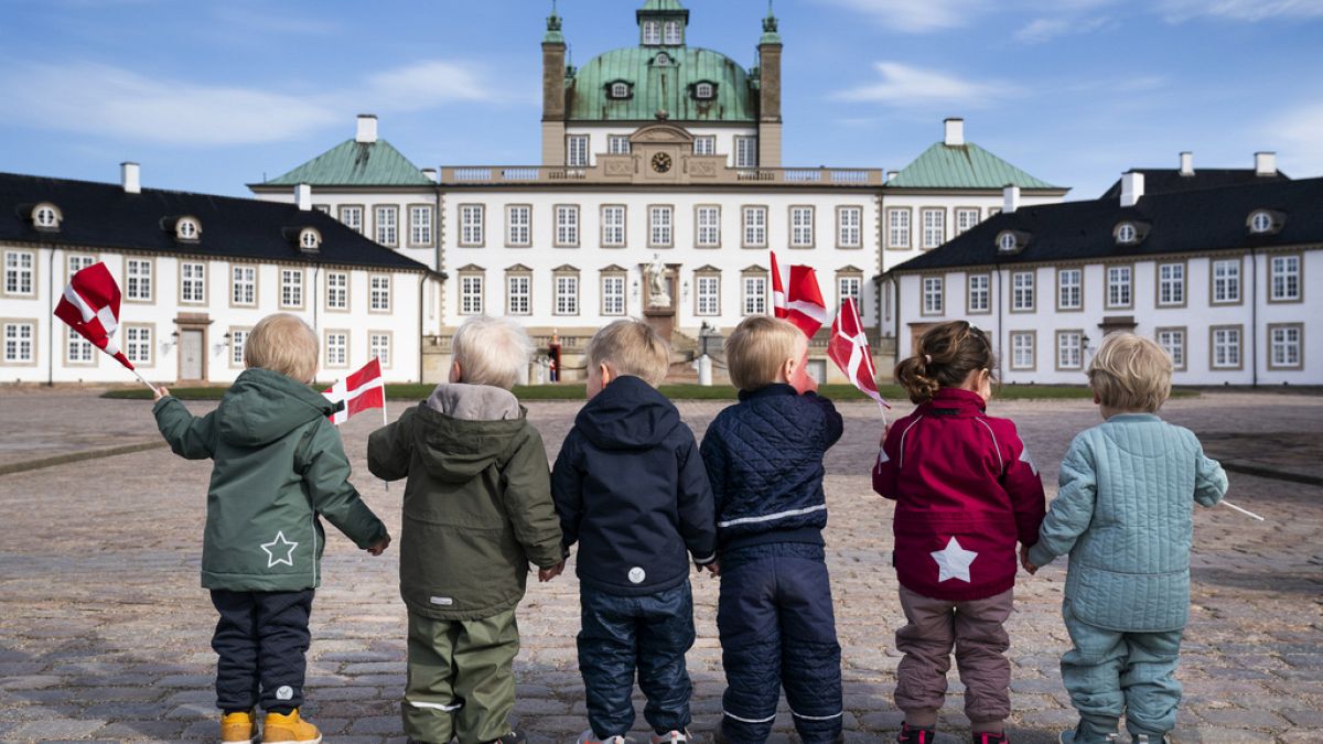Children wave Danish flags as they celebrate Denmark