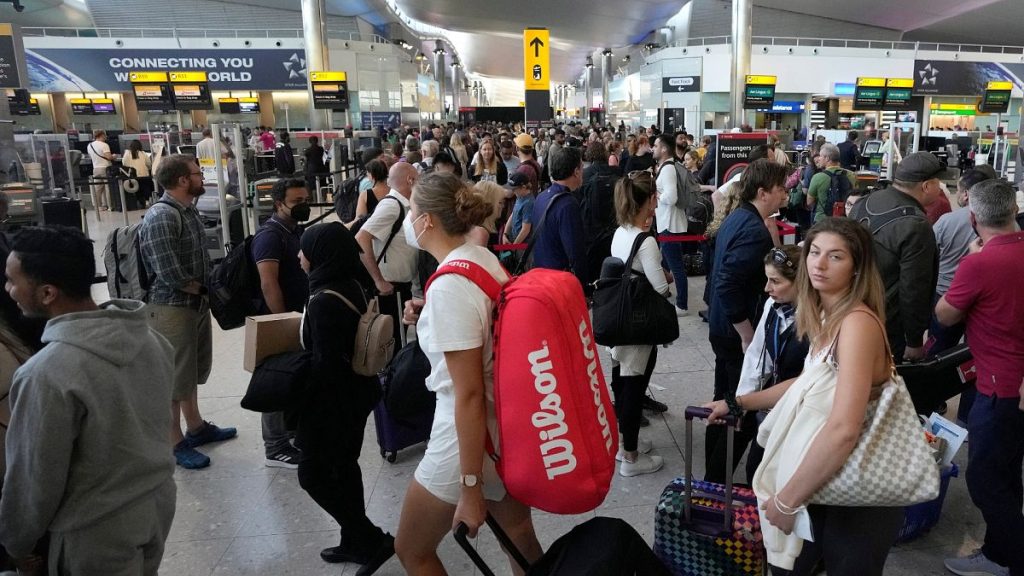 Travellers queue at security at Heathrow Airport in London.