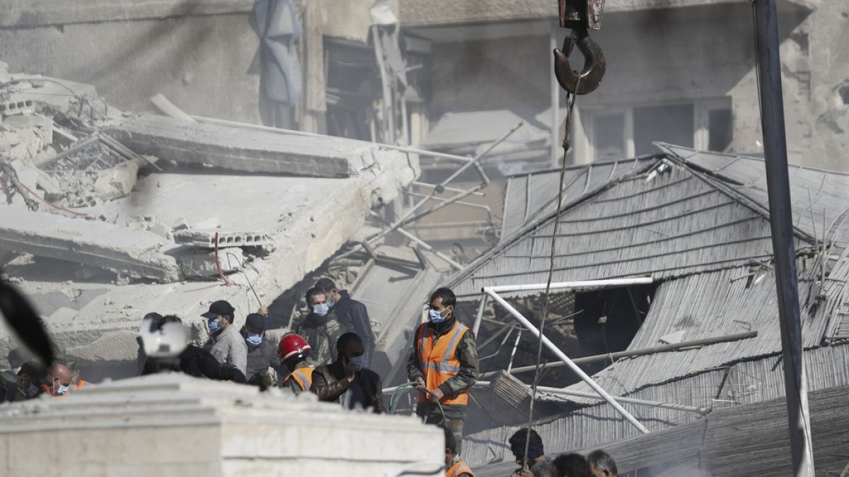 Emergency services work at a building hit by an air strike in Damascus, Syria on Saturday