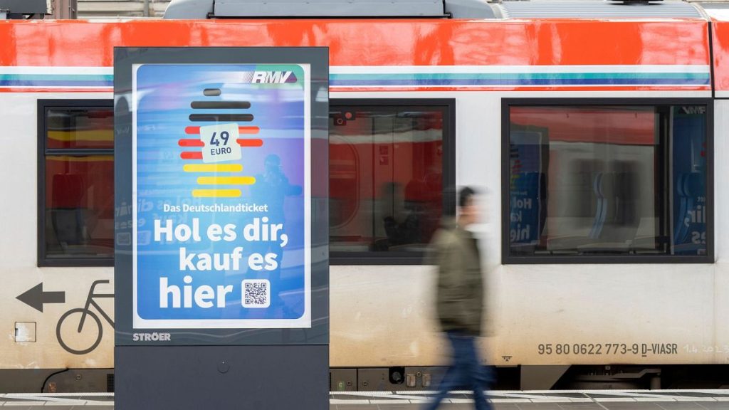 A man passes by an advertising for the Deutschlandticket (Germany Ticket) at a train station in Frankfurt, Germany, Monday, May 1, 2023.