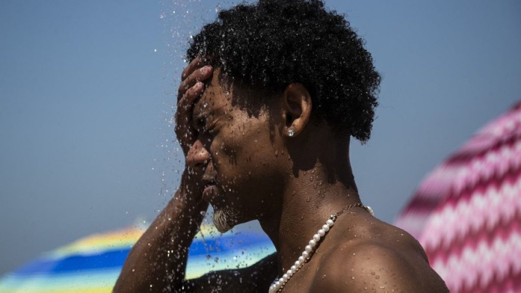 A man cools off in a shower at Ipanema beach, Rio de Janeiro, Brazil in September