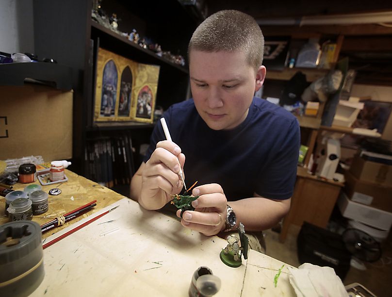 Thomas Severson peint à la main l'une de ses milliers de figurines Warhammer 40 000 à Dubuque, Iowa.