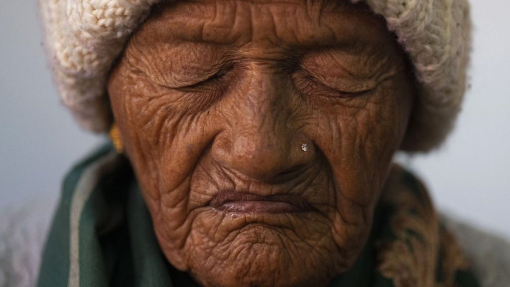 An elderly woman prays at a church in Kathmandu, Nepal. Dec. 25, 2023.