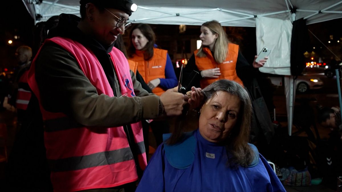 A hairdresser cutting a woman