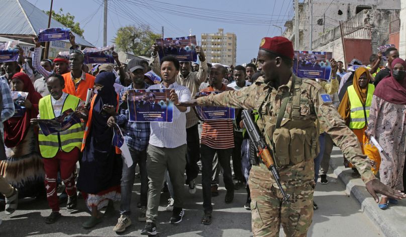 Un soldat somalien contrôle la foule alors que des milliers de personnes assistent à un rassemblement de protestation à Mogadiscio, janvier 2024.