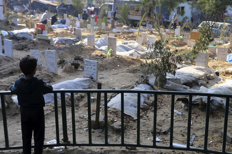 Un enfant palestinien regarde les tombes des personnes tuées lors du bombardement israélien de la bande de Gaza et enterrées dans l'enceinte de l'hôpital Shifa, dans la ville de Gaza.