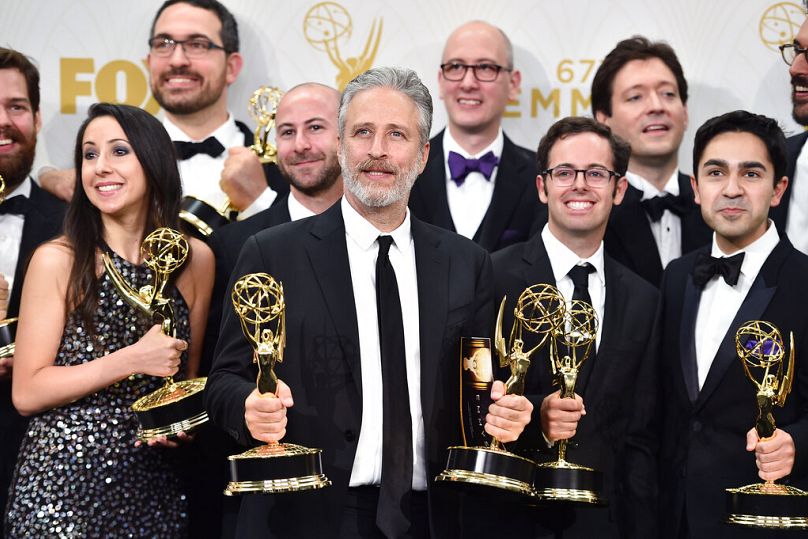 Jon Stewart avec les acteurs et l'équipe pour recueillir le prix Emmy pour une série de variétés exceptionnelle pour 