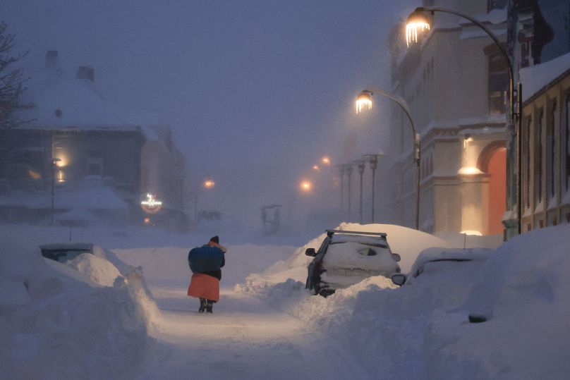 Des gens se frayent un chemin à travers la tempête de neige à Kristiansand, en Norvège, le mercredi 3 janvier 2024.