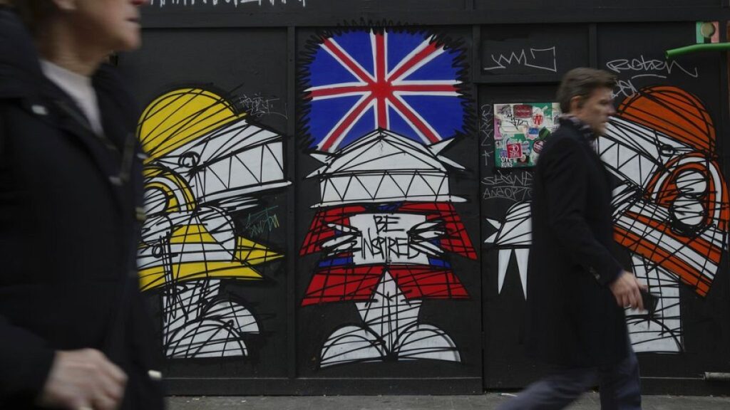 People walk along a street in a shopping district in central London. Jan. 13, 2023.