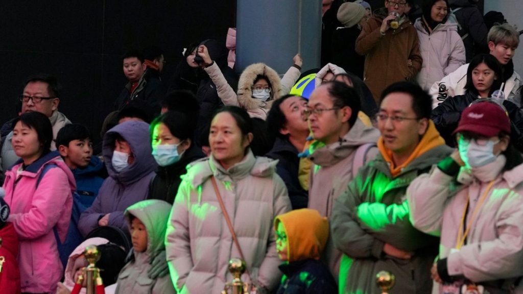 A child, center back, reacts in a crowd at a shopping mall in Beijing on Dec. 30, 2023. China’s population dropped by 2 million people in 2023 in the second straight annual dr