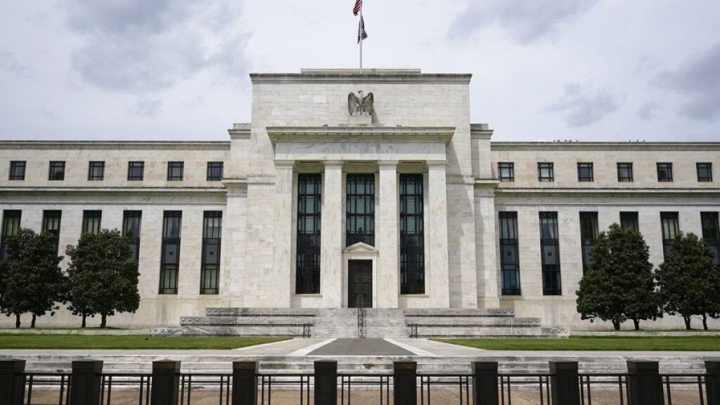 FILE - An American flag flies over the Federal Reserve building on May 4, 2021, in Washington. The nation’s 33 biggest banks have enough capital to withstand a severe economic