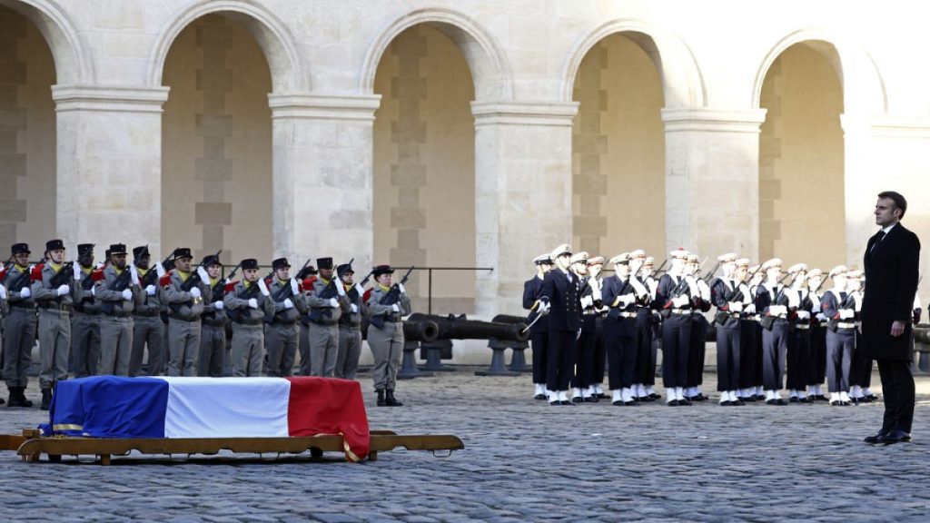 French President Emmanuel Macron honors the coffin of late French politician and former European Commission President Jacques Delors in the courtyard of the Hotel des Invalide