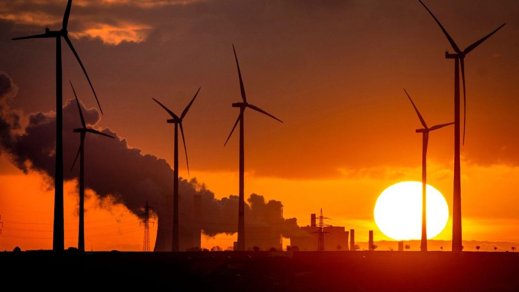 Steam rises from the coal-fired power plant near wind turbines Niederaussem, Germany, as the sun rises on 2 November 2022.