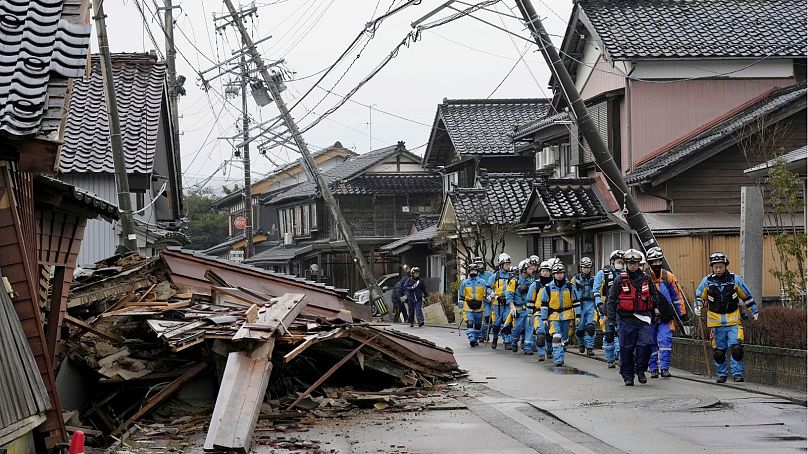 La police passe devant des maisons effondrées touchées par des tremblements de terre à Suzu, préfecture d'Ishikawa, au Japon, le mercredi 3 janvier 2024.