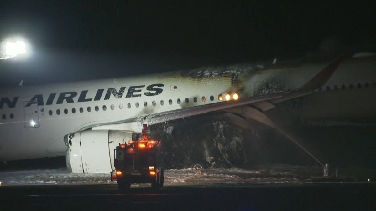 A Japan Airlines plane damaged by fire at Haneda Airport.